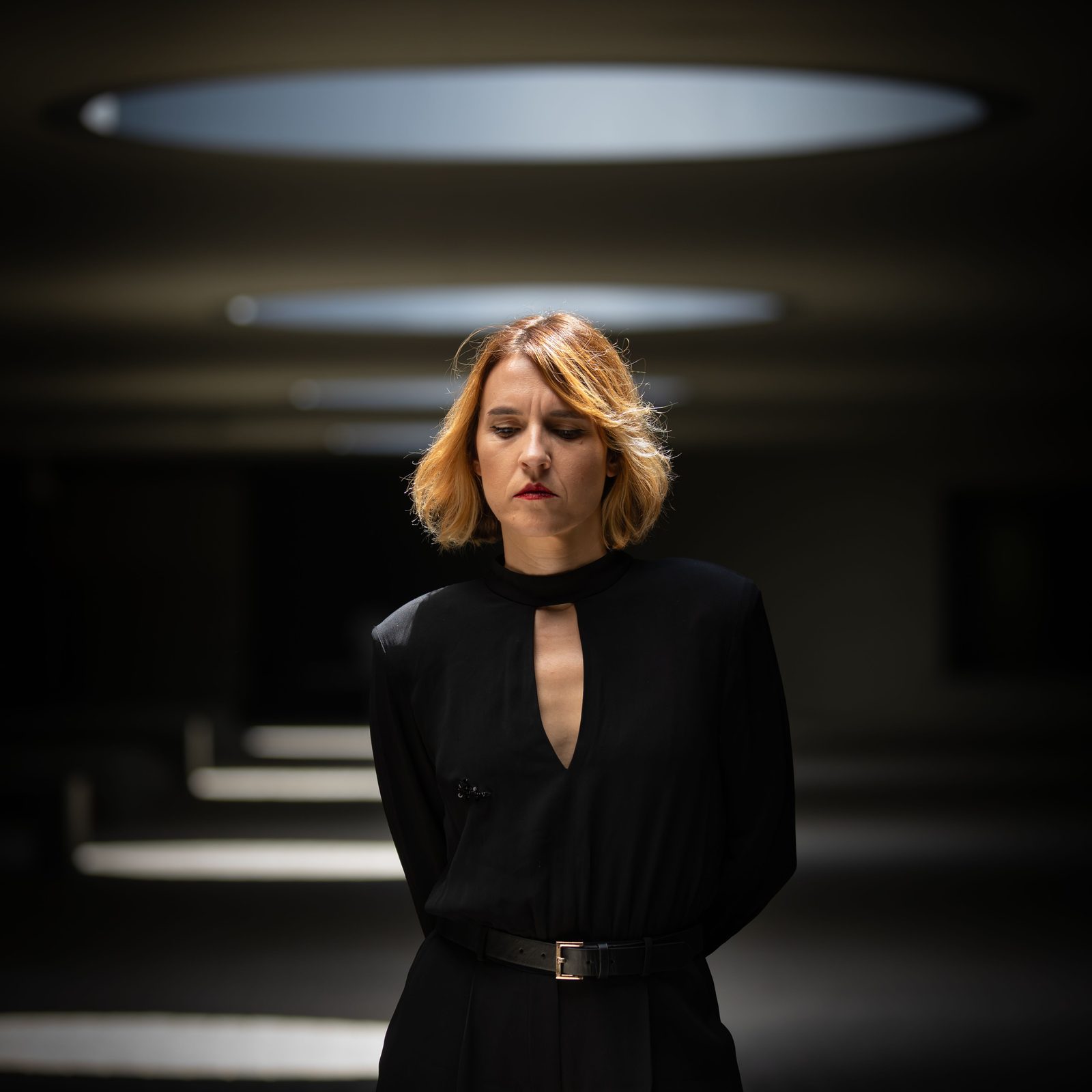 Retrato de Mobox, con melena rubia y ropa negra, bajo unas luces circulares.